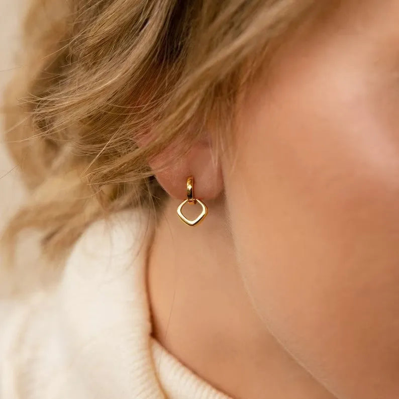 Double ring twist geometric square ear clip simple copper earrings on a neutral background