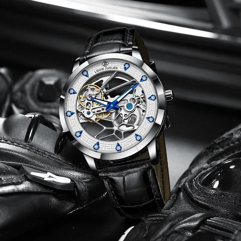 Men's silver-cased mechanical watch with white dial, blue hands, black leather strap, and butterfly buckle.