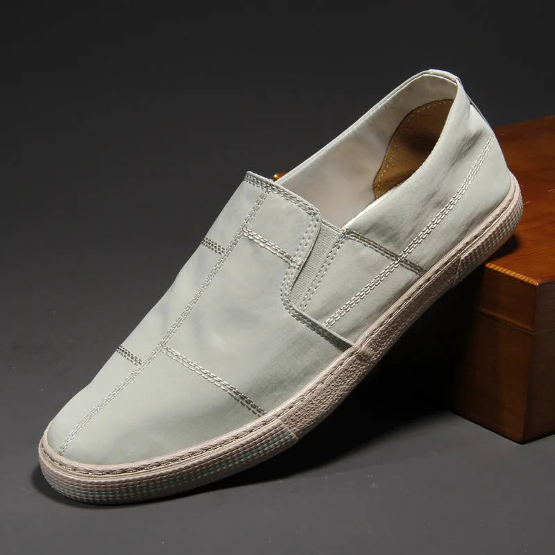 Men's low-top slip-on canvas shoes in various colours showing round toe and vulcanised rubber sole.