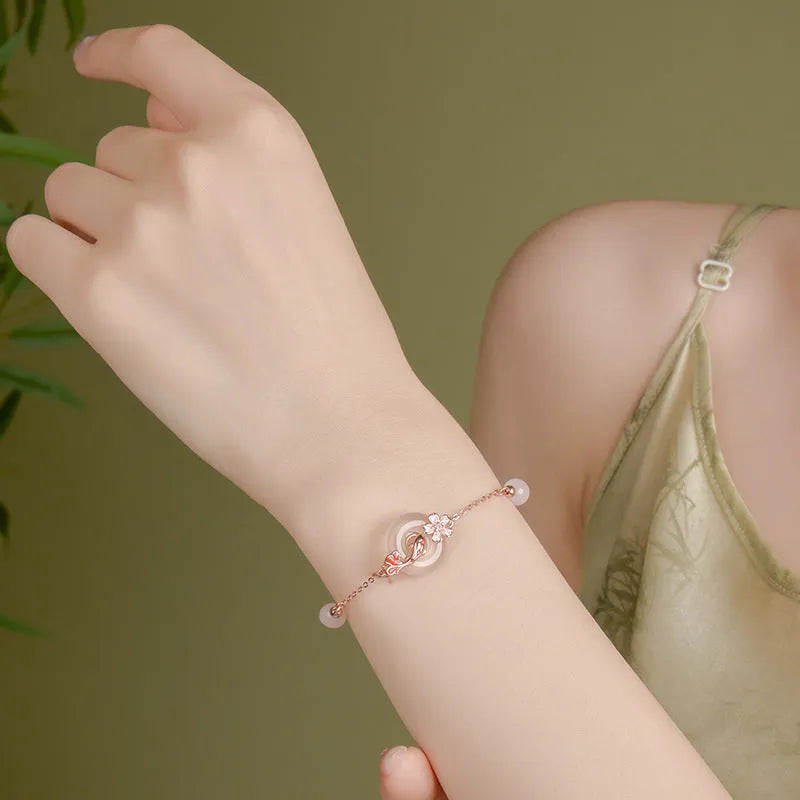 S925 sterling silver bracelet with white chalcedony beads and a gold-toned koi fish charm.