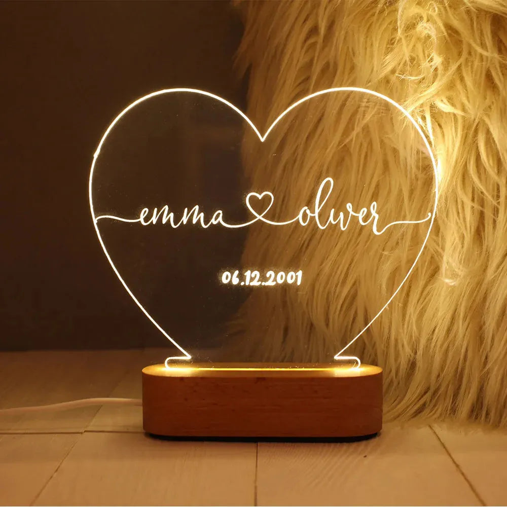 Custom transparent acrylic night light with personalised text, lit by LED, on a bedside table.