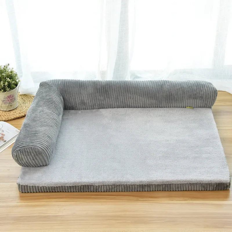 Grey corduroy pet sofa dog bed with bilateral bolsters and a non-slip cloth base on a wooden floor.