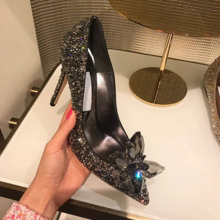 Women's gold stiletto high heel with pointed toe, rhinestone decorations, and a bow.