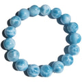 Blue Bodhi bead bracelet with white pearl accents on a plain background.