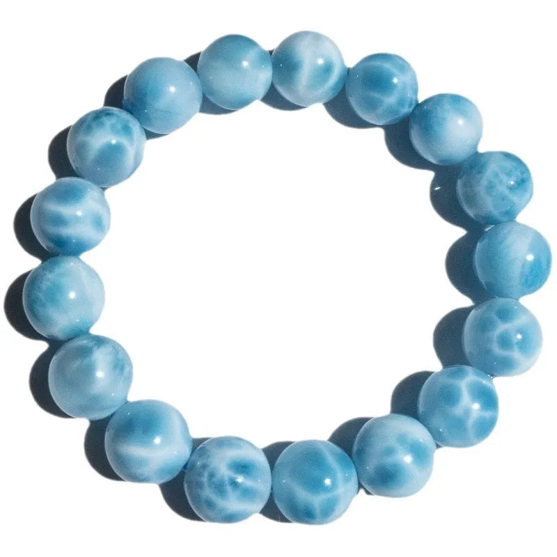 Blue Bodhi bead bracelet with white pearl accents on a plain background.