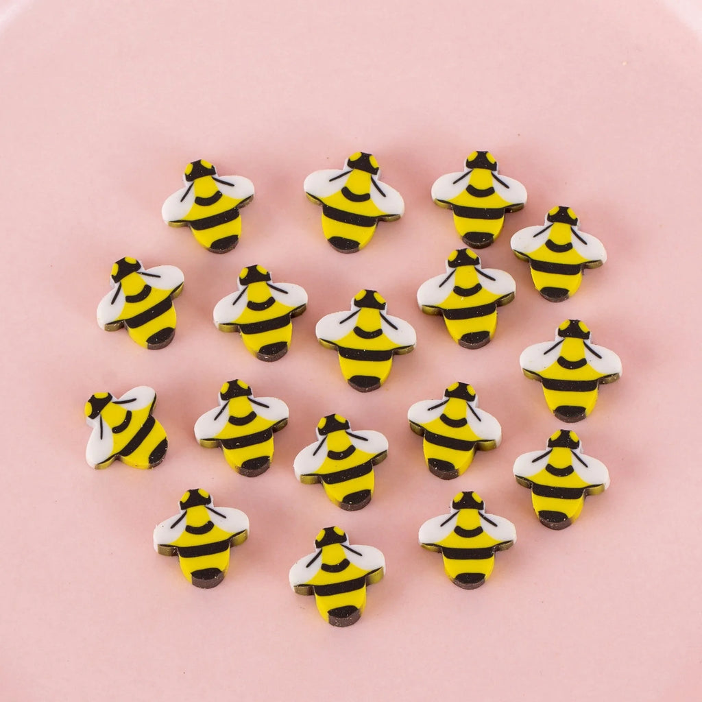Assortment of 50 colourful mini cartoon erasers in shapes of fruits, animals, and cakes on a white background.