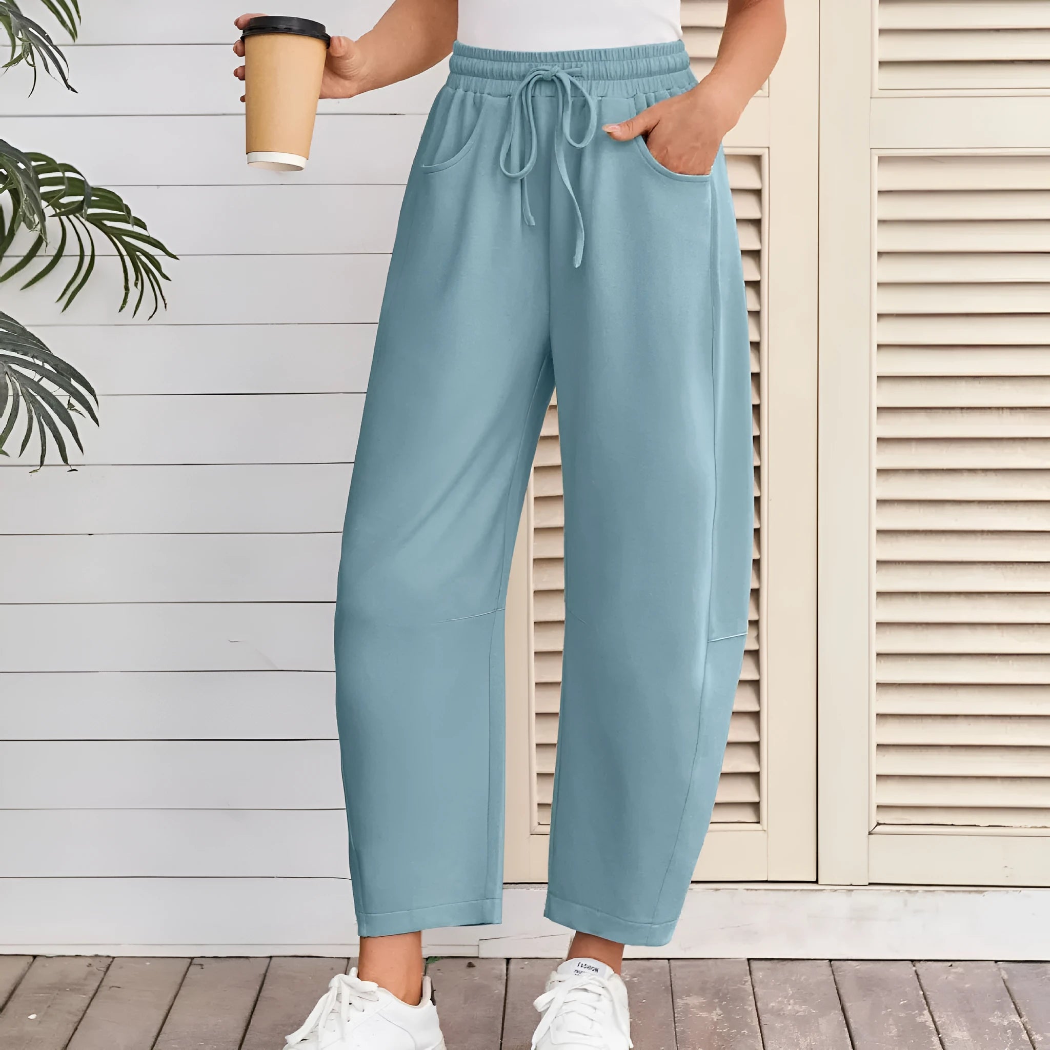 Women's loose cropped sweatpants with elastic drawstring waist in apricot colour showing side pockets and street fashion styling