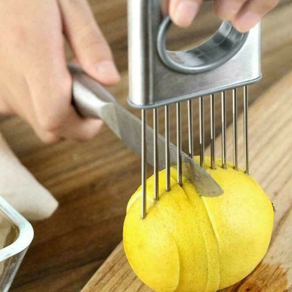Stainless steel onion holder slicer kitchen tool with sharp prongs and finger guard on a cutting board.