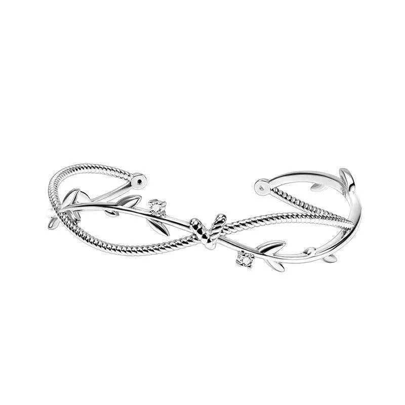 Cross twisted white gold electroplated bracelet with tree charm on copper base.