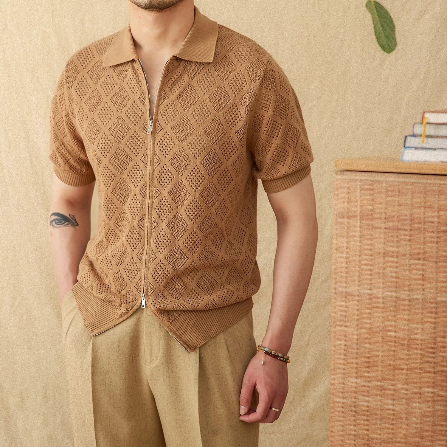 Man wearing a light brown, short sleeve cotton cardigan with a front zipper and lapel collar.