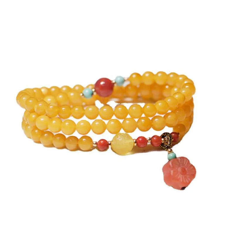 Yellow chicken grease coloured amber bracelet with animal zodiac charm on a white background.