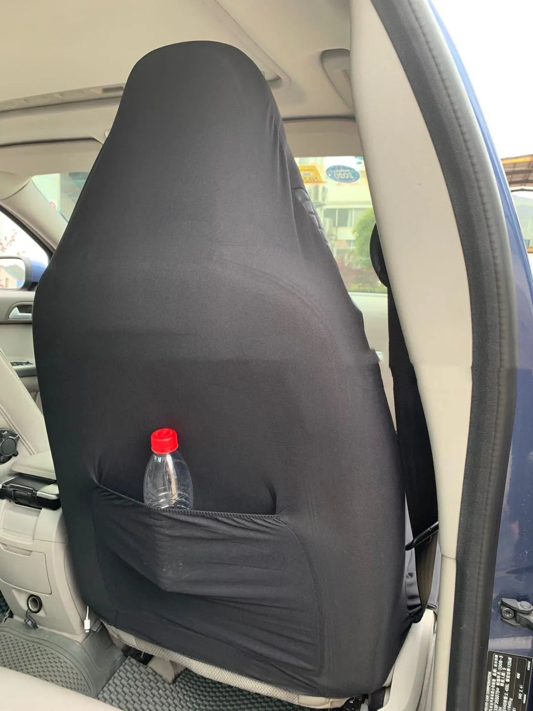 Black quilted automotive seat cover made of PU and polyester fabric, shown with plastic attachment hooks.