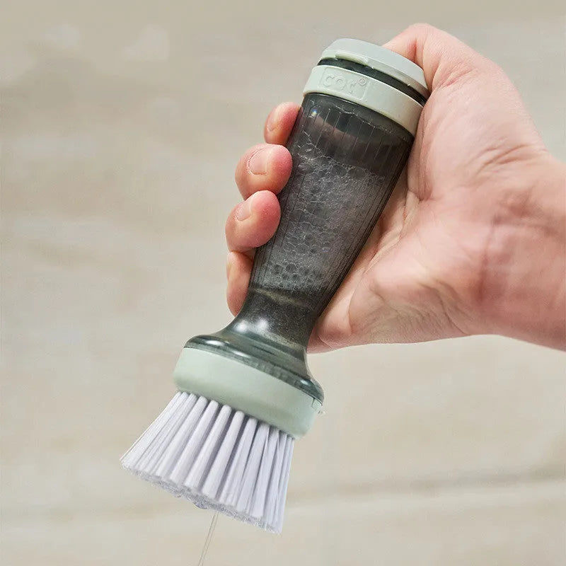 Milk white pot brush with soap dispenser in handle and non-scratch bristles for kitchen sink use.