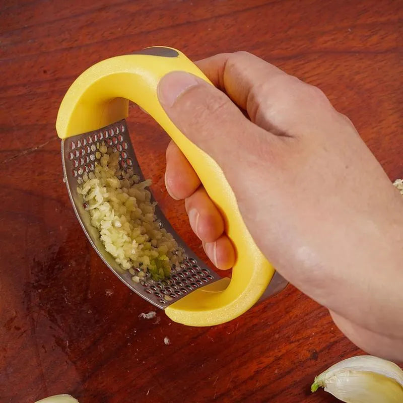 Stainless steel garlic press with ergonomic handle in available colours for kitchen use