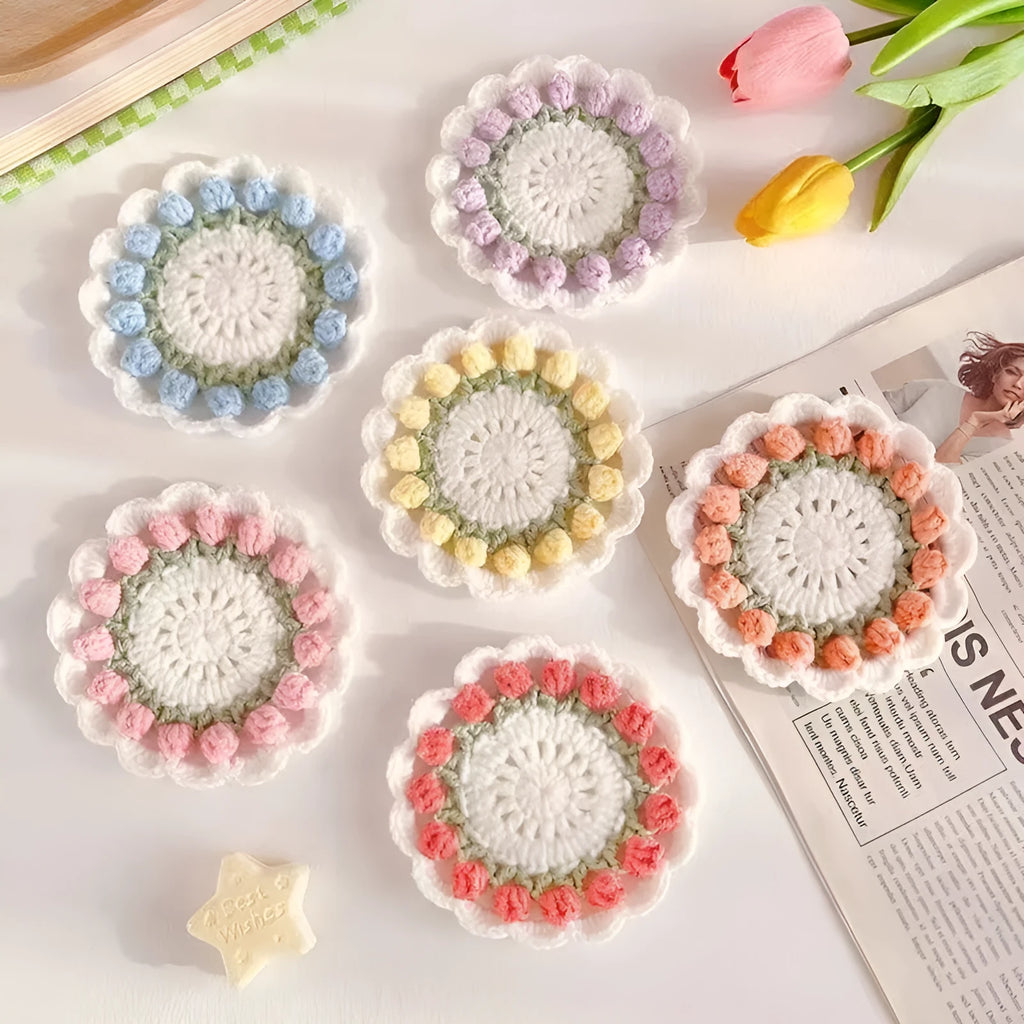 Handmade woven floral coaster in cotton and linen on a wooden table