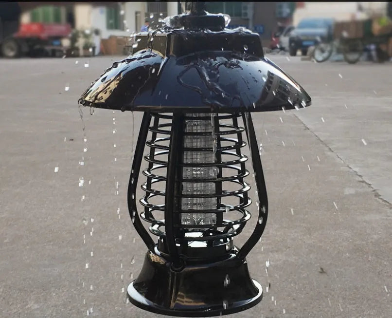 White outdoor solar mosquito lamp with solar panel on top and LED light beads, shown in a garden setting.