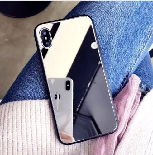Black iPhone phone case with a built-in circular mirror on the back, shown next to an iPhone.