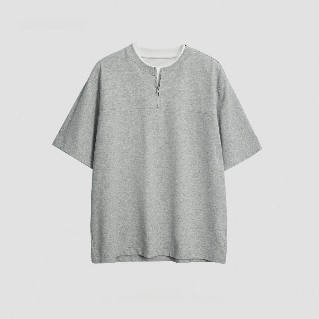 Women's loose blue patchwork top with false two-piece design on a hanger.