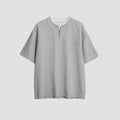 Women's loose blue patchwork top with false two-piece design on a hanger.