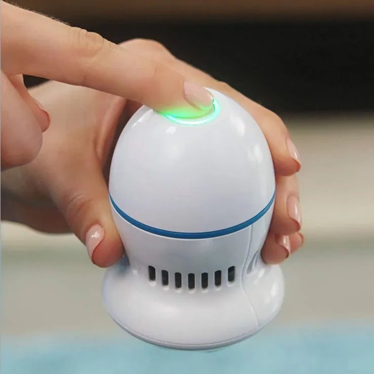 Beige and white electric foot file grinder with USB cable and two diamond grinding heads on a plain background