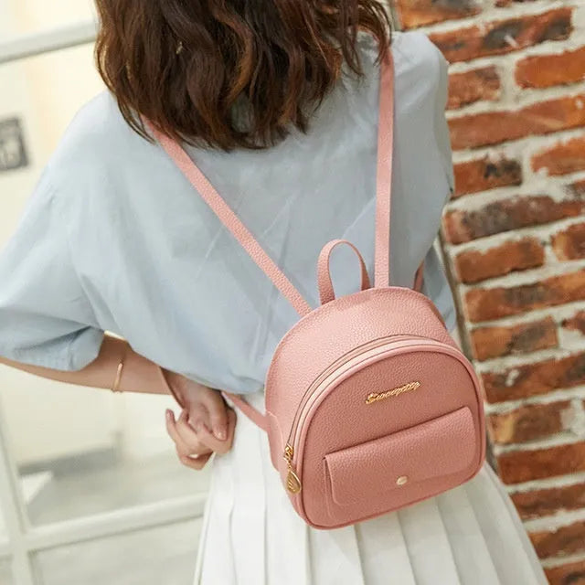 Black PU women's small backpack convertible to a shoulder bag, shown with a mobile phone for scale.