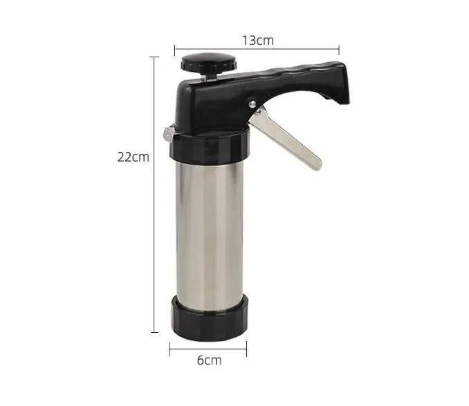 Stainless steel biscuit press gun with set of cookie moulds and piping nozzles on baking tray