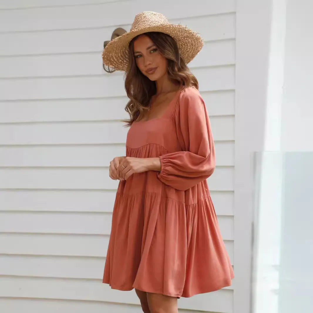 Orange children's backless dress with a square collar and puff sleeves, showing A-line skirt.