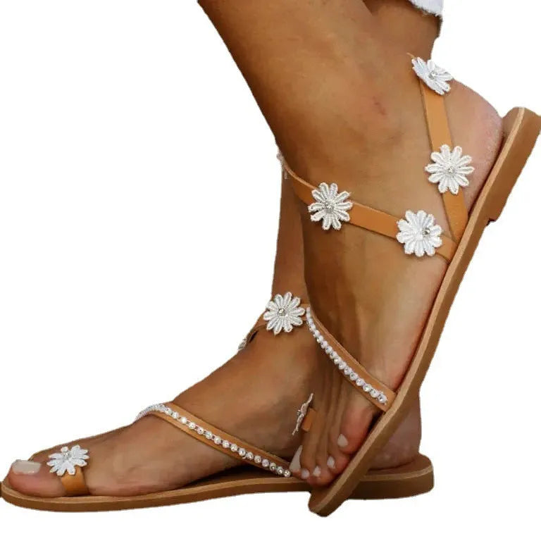 Brown women's Roman sandals with floral pattern, flat rubber sole, and herringbone toe design.