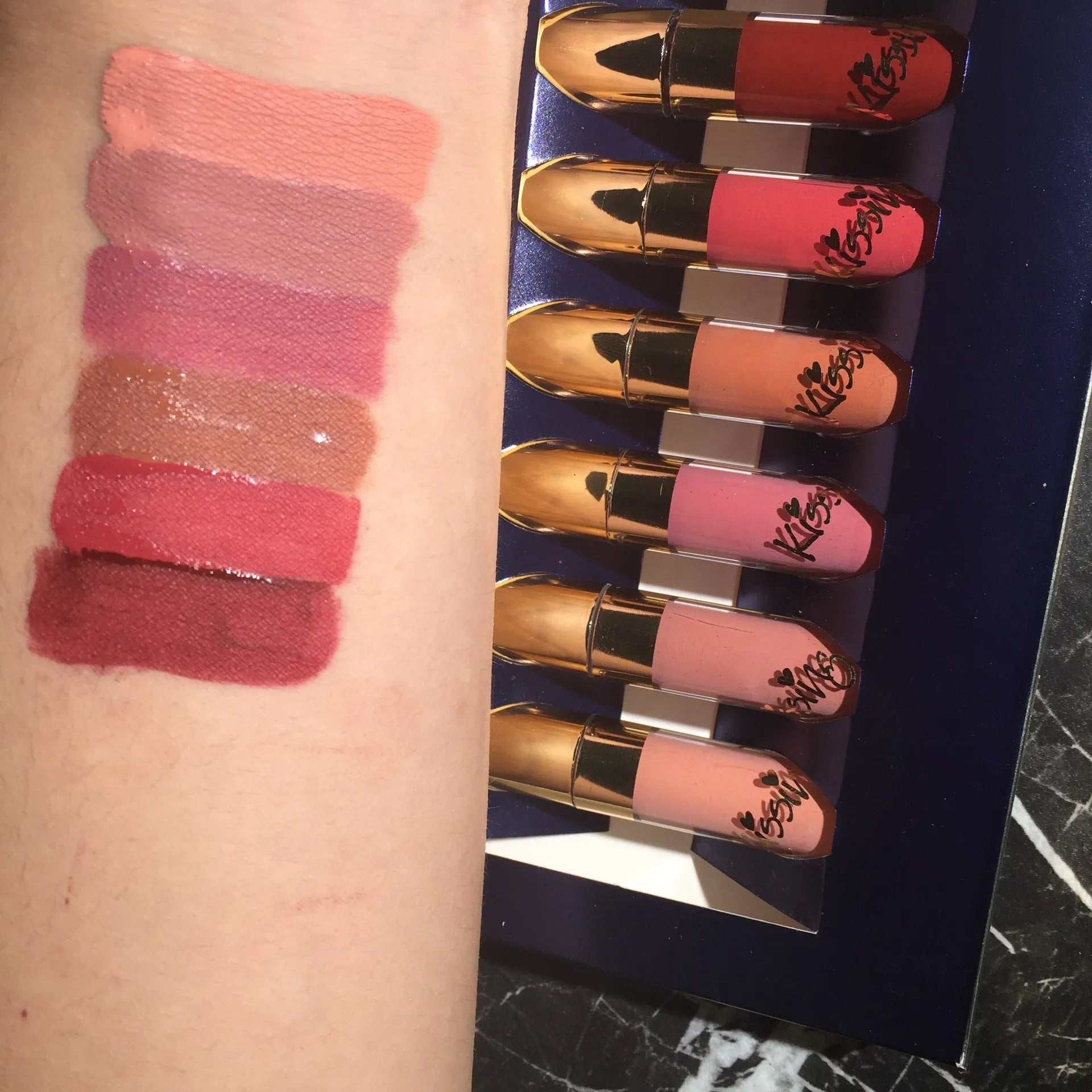 Six tubes of liquid matte lipstick in assorted shades laid out on a white background