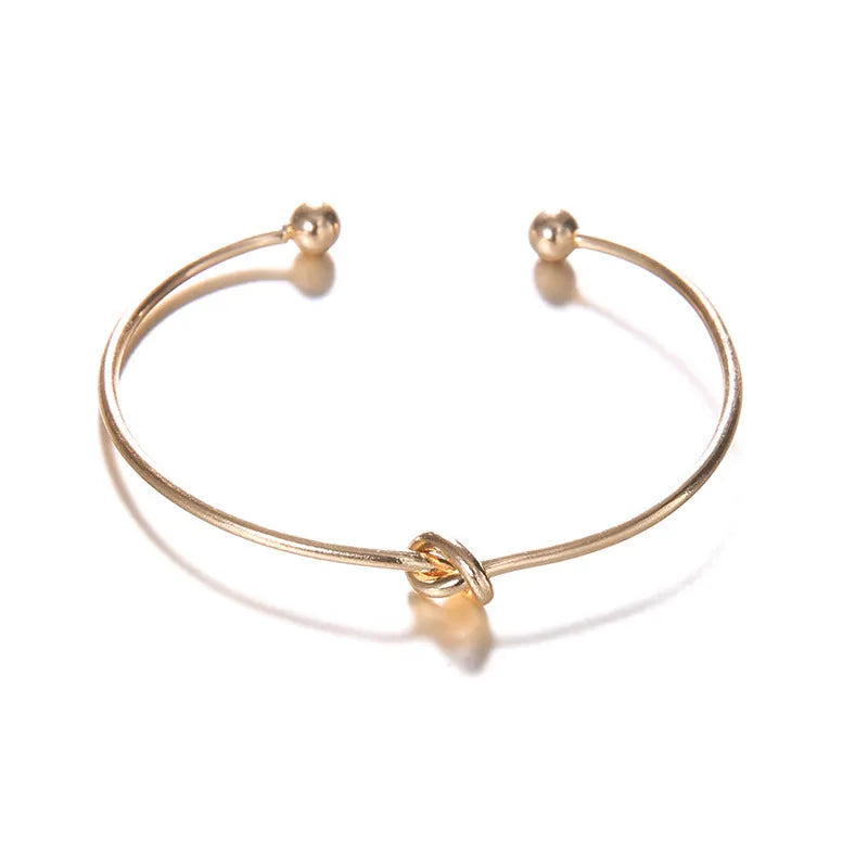 Gold vintage cuff bracelet for women with an arrow design and knotted detail.