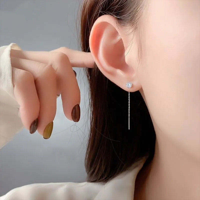 Round zirconium stud earrings with tassel rhinestone hanging in white gold colour on a geometric silver base