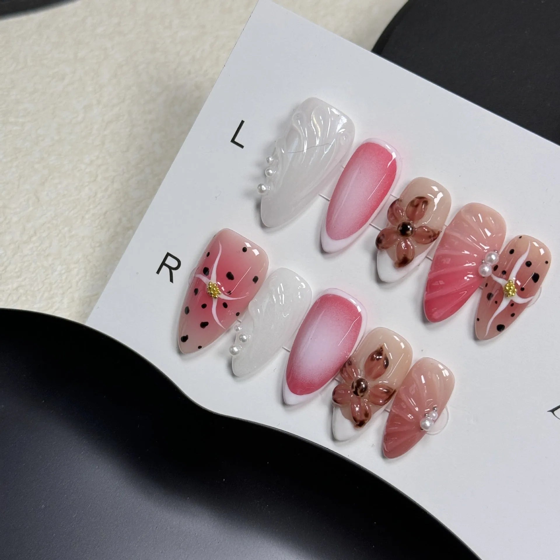 Set of hand-painted 3D carved nail beauty patches in embossed and candy patterns on a plastic sheet.