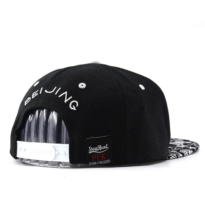 Cotton baseball cap with embroidered letters in black or white, showing adjustable strap and dome crown.