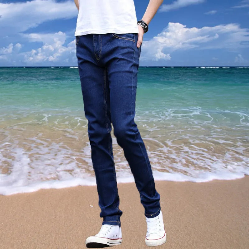 Thin men's loose skinny casual jeans in pure black with low waist, cropped leg, small leg opening, and zip fly.