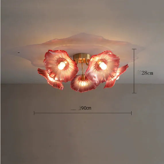Modern white flower-shaped ceiling lamp with multiple heads and remote control on a table.