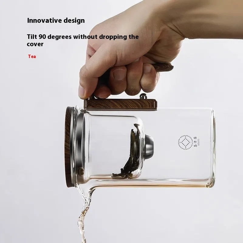 Chinese-style glass teapot with wooden handle showing magnetic filtration button and inner infuser container.