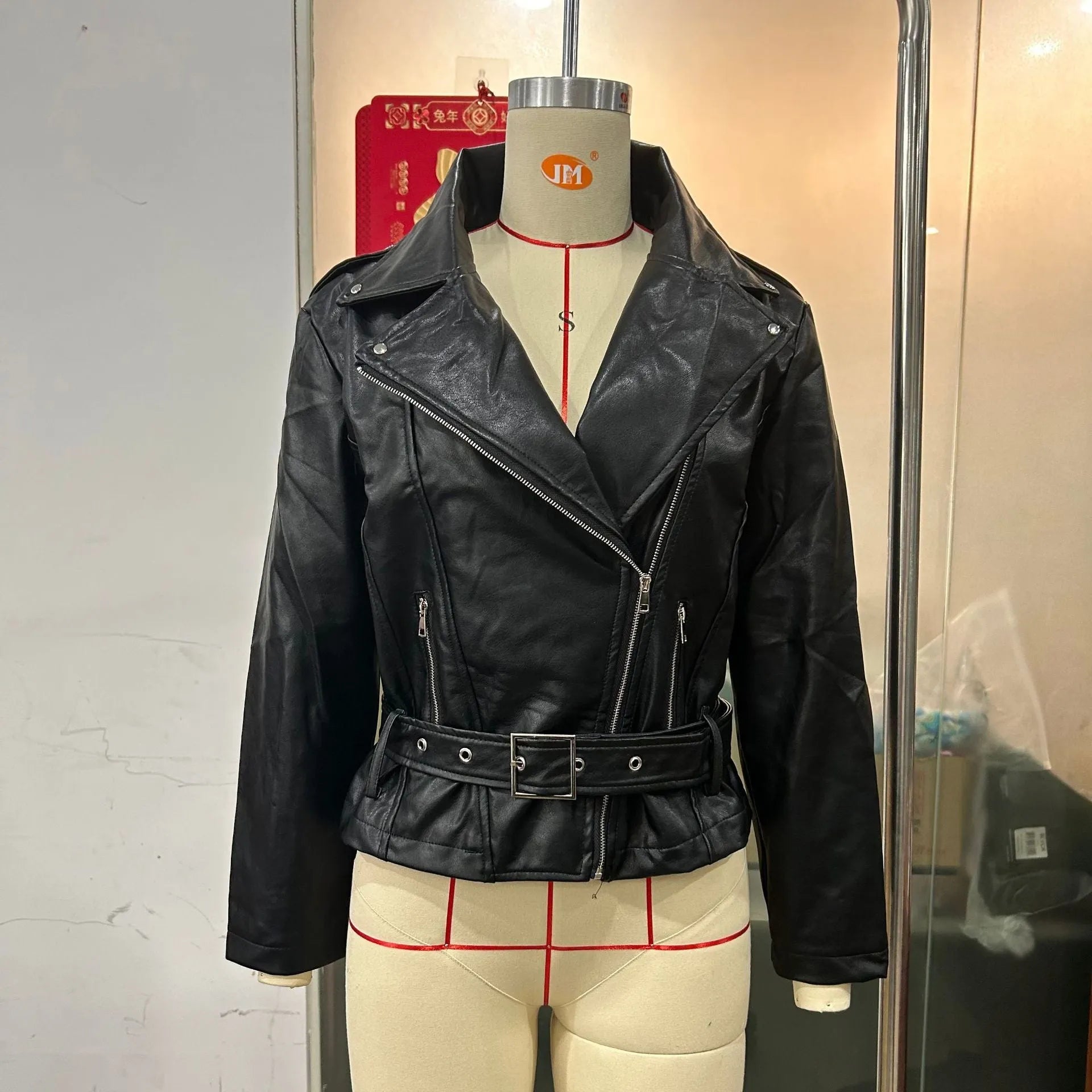 Black punk style short jacket with a belt-fastened lapel and Peter Pan collar.