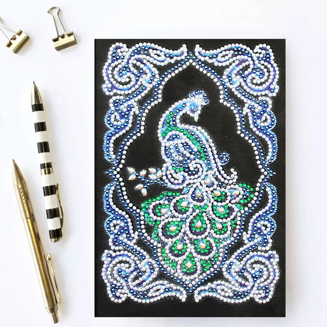 Black A5 diamond painting notebook with peacock design, open to show shaped and bright drills on page.