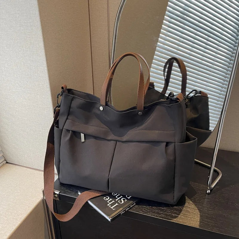 Nylon crossbody bag with adjustable strap in black colour, showing tote design with 39cm length