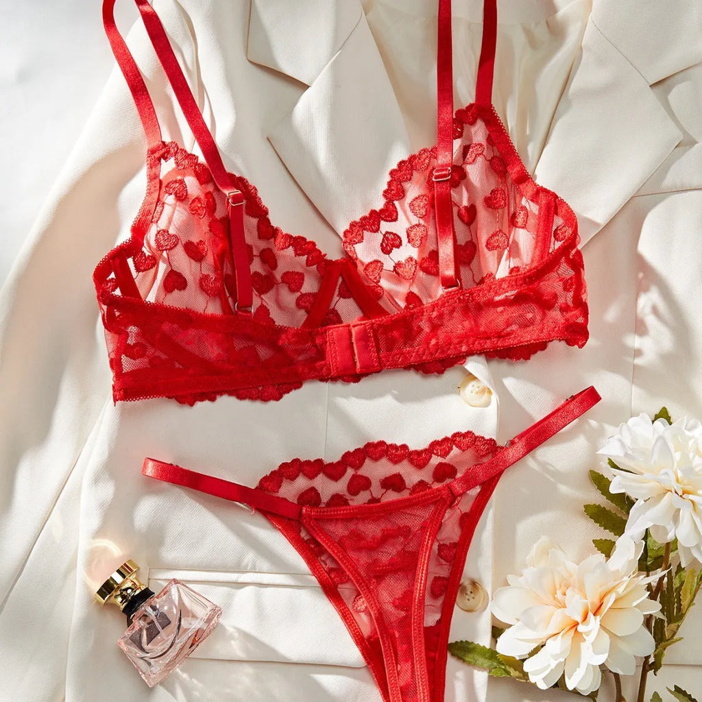 Women's red mesh two-piece suit set with top and trousers on a hanger.