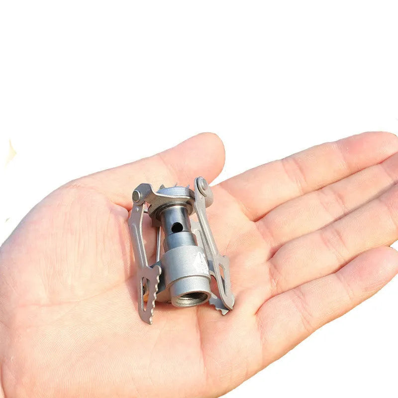 Portable propane gas camping stove with a one-piece metal furnace structure.