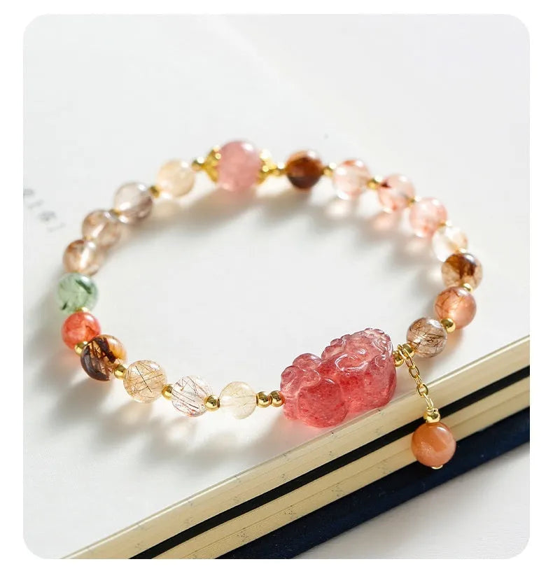 Women's copper bracelet with strawberry quartz crystal, Pixiu charm, and pearl beads.