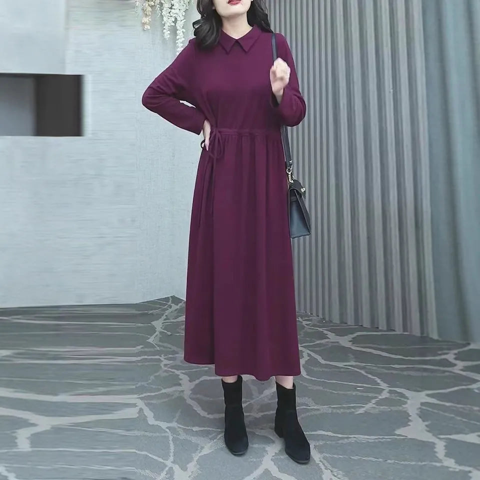 A purplish red plus size long sleeve midi dress for women, shown in an urban style.