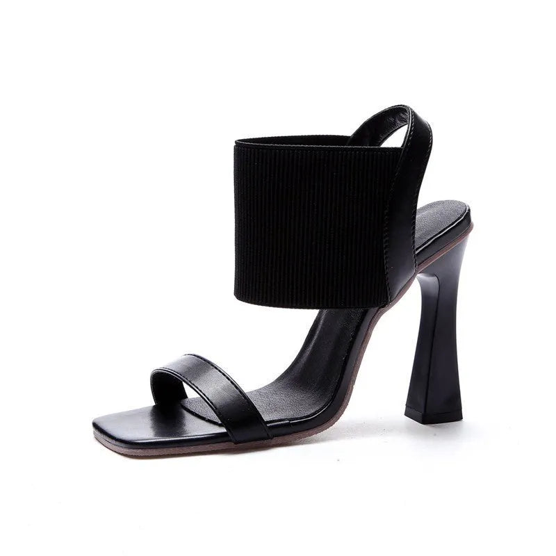 Women's high heel sandals with elastic straps in black, shown from the side.