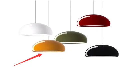 Danish-style iron pendant lamp with adjustable cord above a restaurant table.