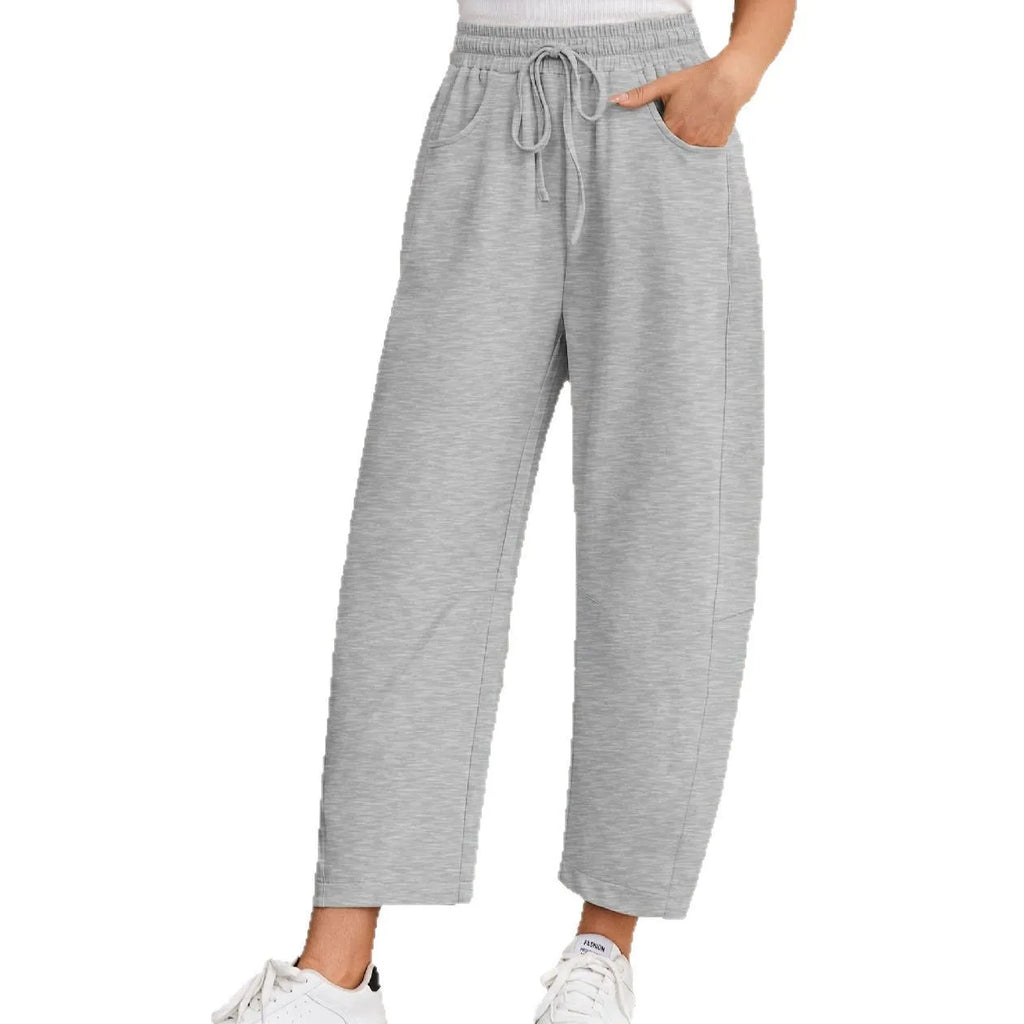 Women's loose cropped sweatpants with elastic drawstring waist in apricot colour showing side pockets and street fashion styling