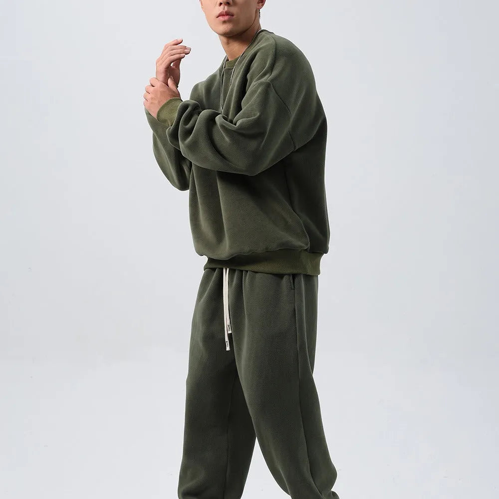 Man wearing a men's army green polar fleece sports suit with long sleeve coat and loose padded trousers.