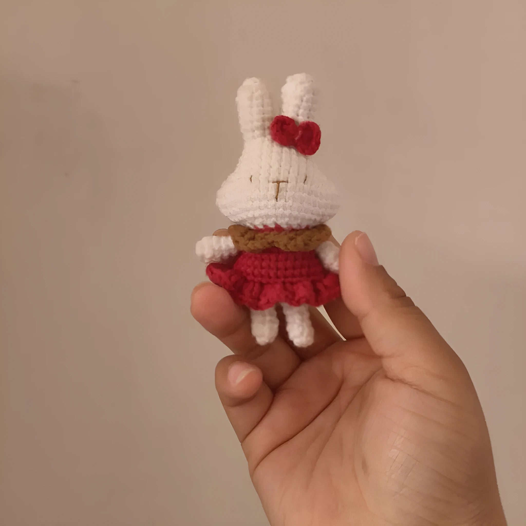 Hand-crocheted wool rabbit keychain pendant on a metal ring.