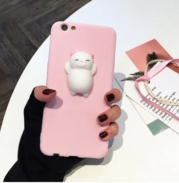 Soft silicone iPhone case with a raised 3D cartoon cat design on the back, shown in pink.