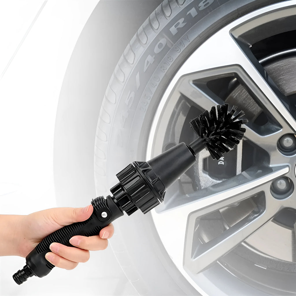 Water-driven rotary cleaning brush in black and yellow plastic connected to a garden hose for car wheel cleaning